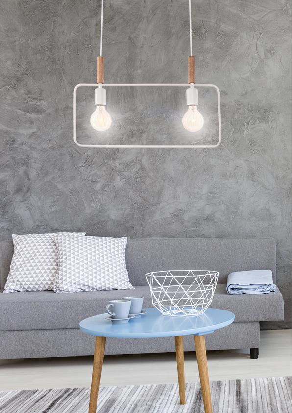Vue rapprochée du luminaire blanc allumé dans un salon gris avec coussins graphiques.