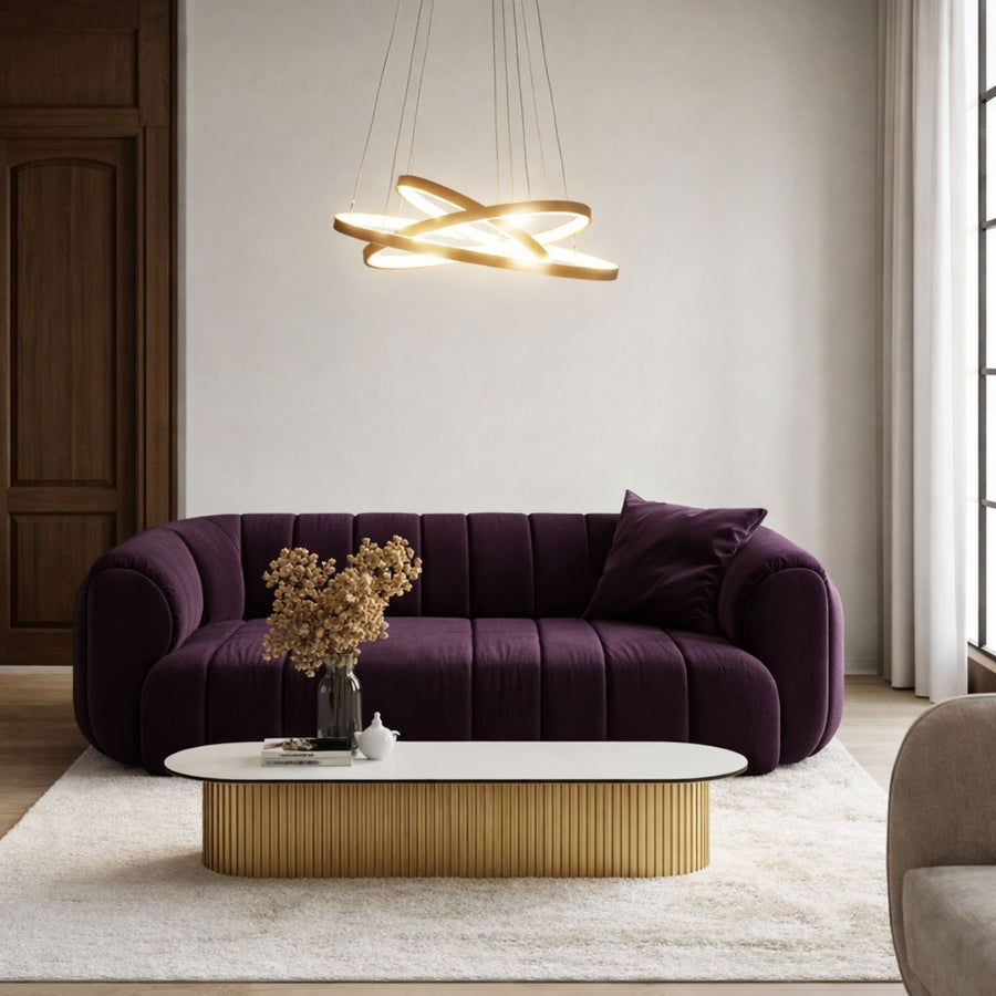 Mise en situation dans un salon avec canapé violet et suspension allumée au-dessus.