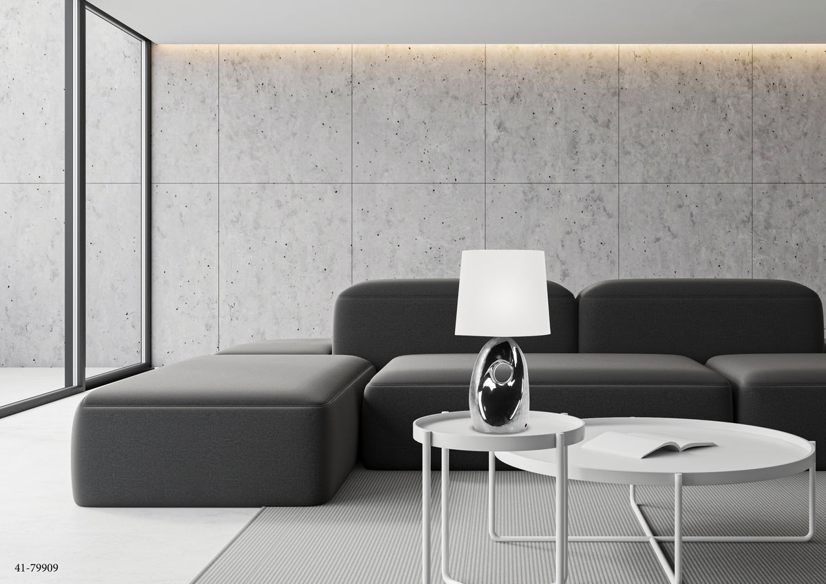Mise en ambiance salon gris, lampe sur table basse, canapé et mur béton