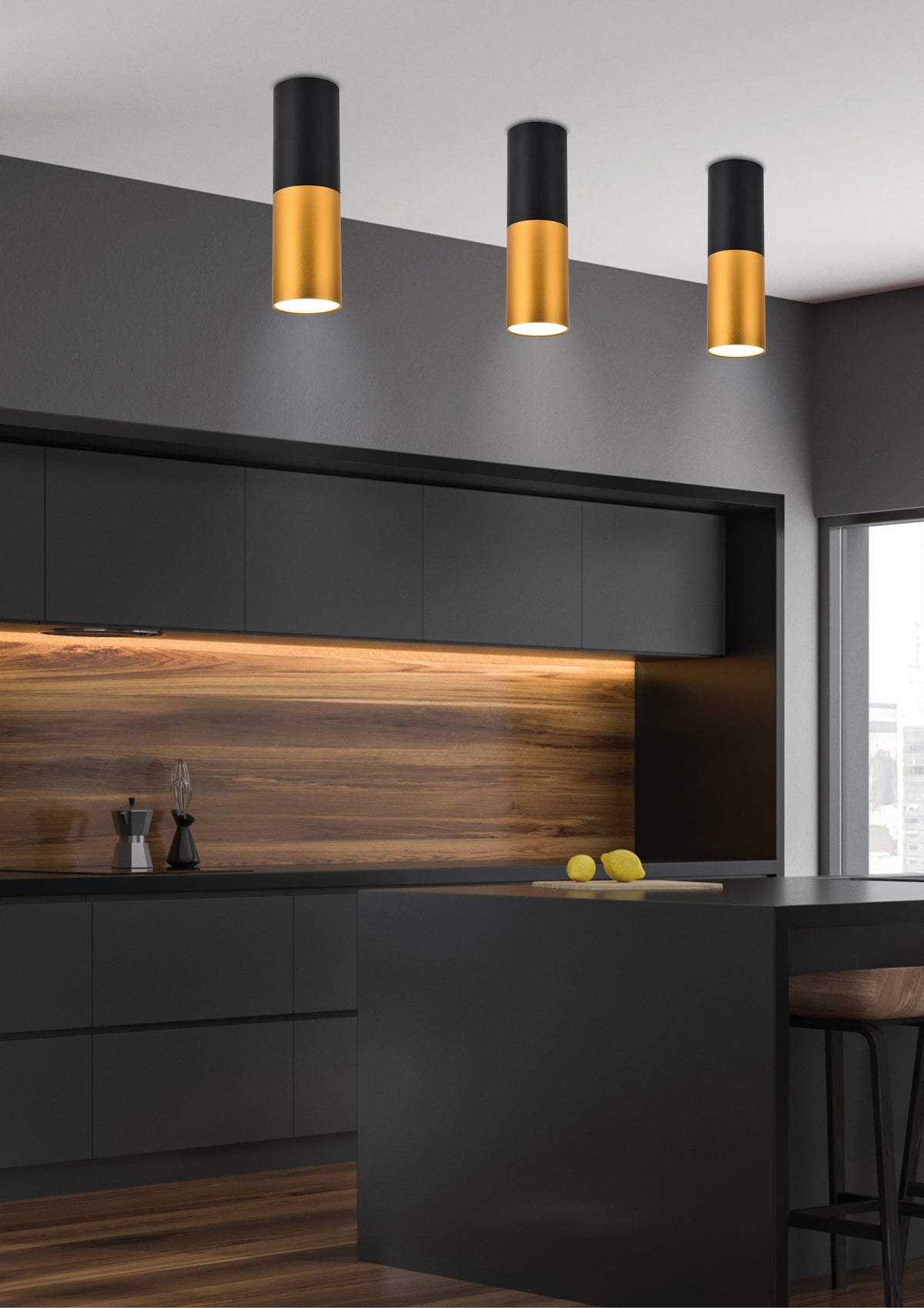 Trois spots cylindriques noirs et dorés fixés au plafond d'une cuisine moderne aux meubles noirs
