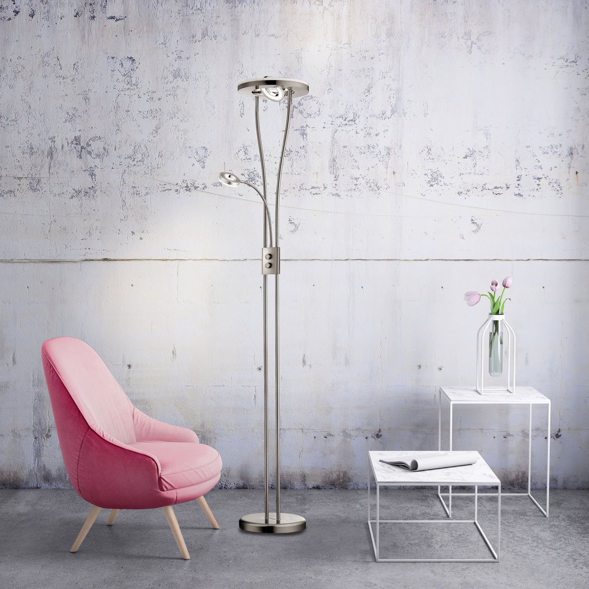 Lampadaire installé dans un salon moderne avec fauteuil rose et table basse en marbre.