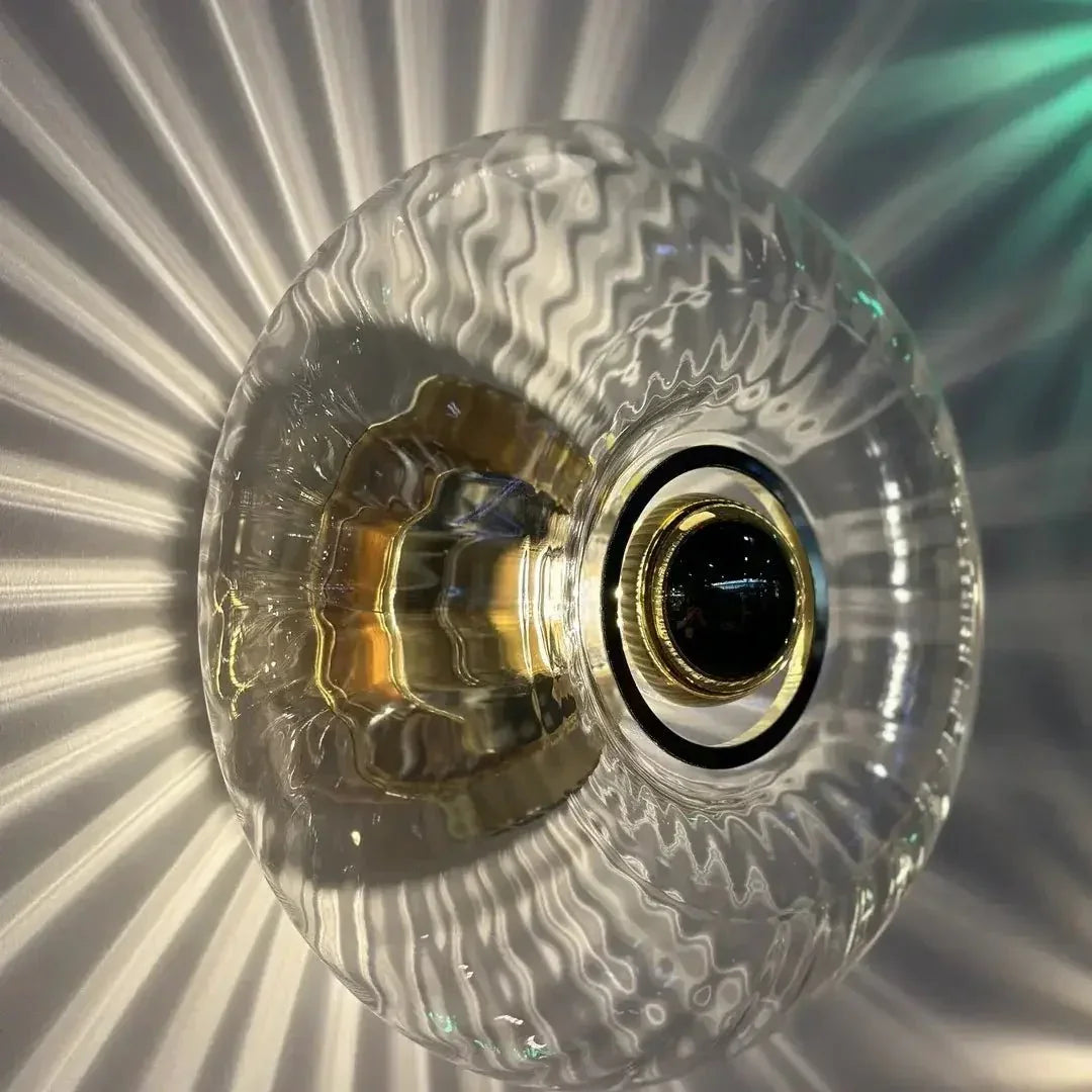 Détail du verre texturé transparent et de la douille centrale dorée de l'applique