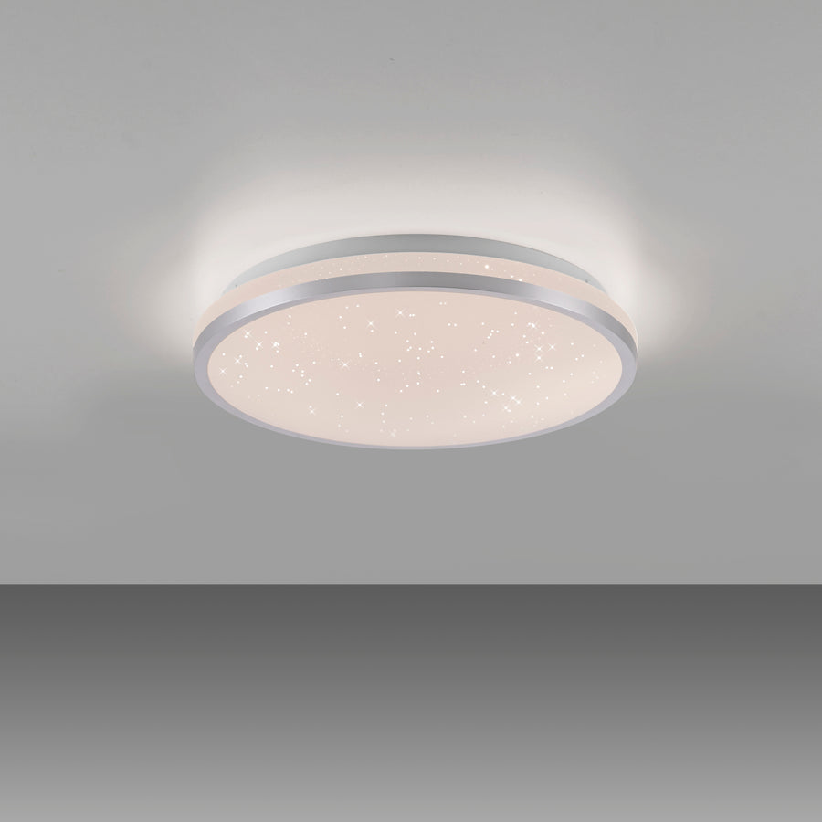 Plafonnier allumé fixé au plafond diffusant un halo de lumière chaude