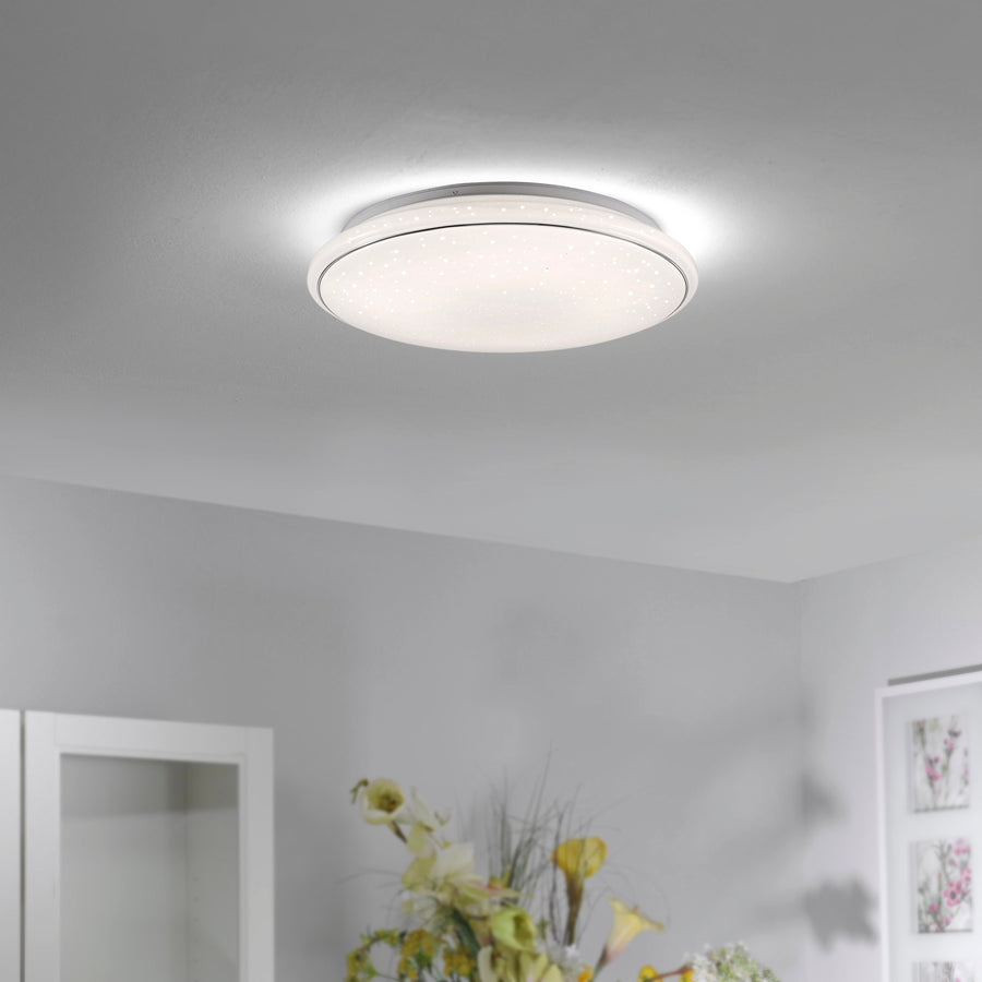 Plafonnier blanc allumé, fixé au plafond dans un intérieur contemporain