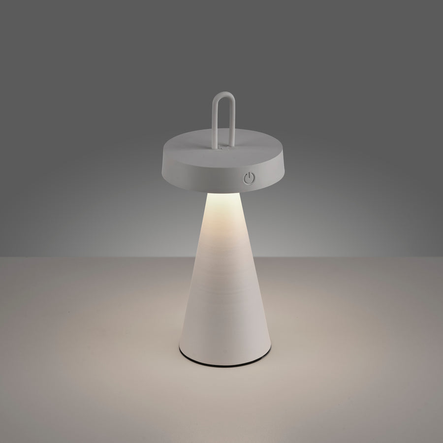 Lampe allumée posée sur surface claire, lumière chaude visible.