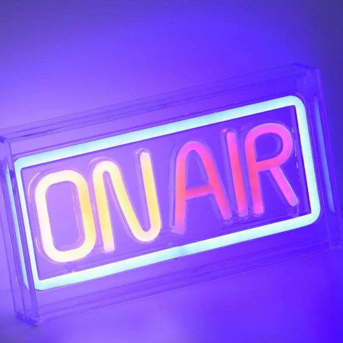 Gros plan incliné du néon ON AIR allumé avec reflets colorés