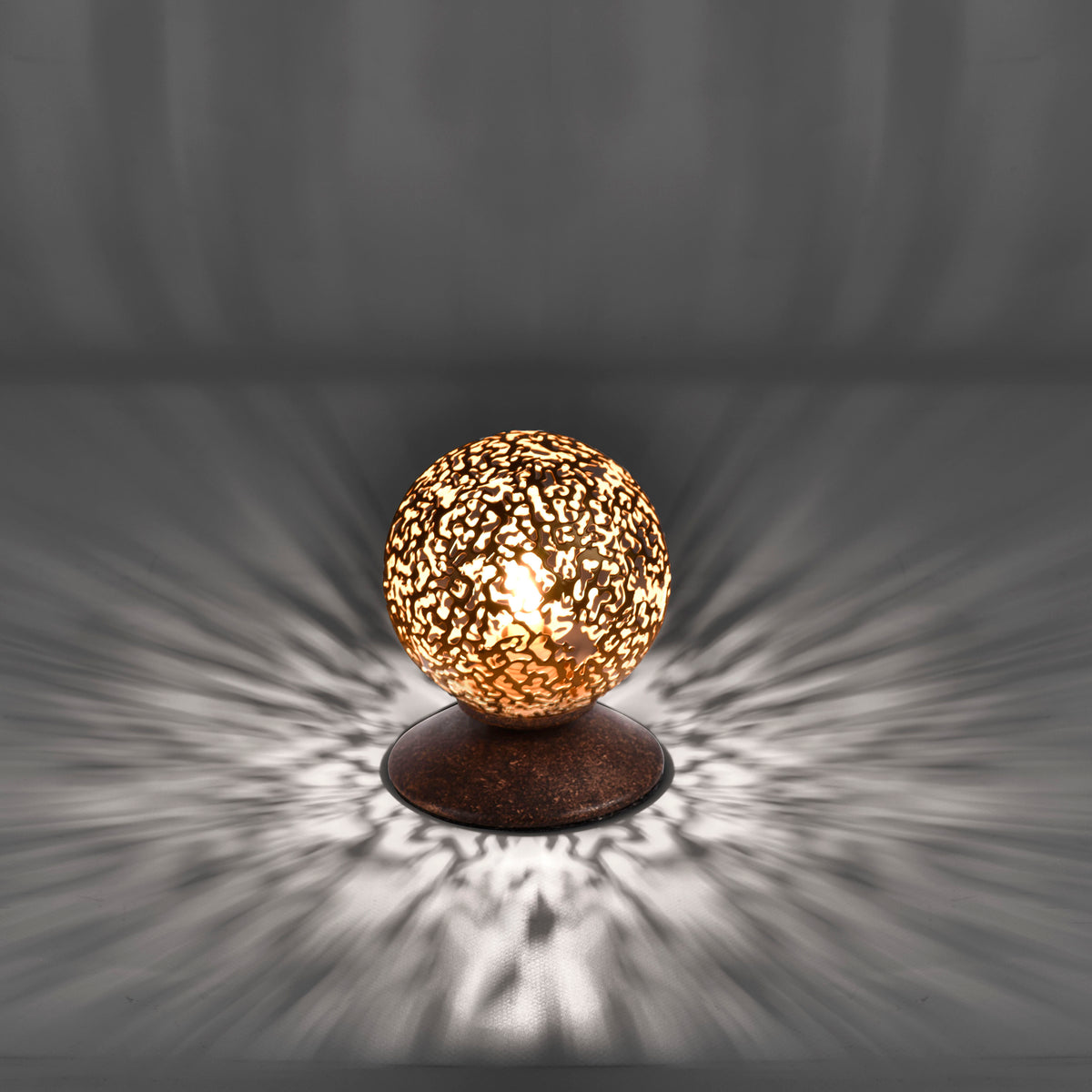 Effet de lumière projeté en rayons étoilés sur une surface grise, lampe allumée
