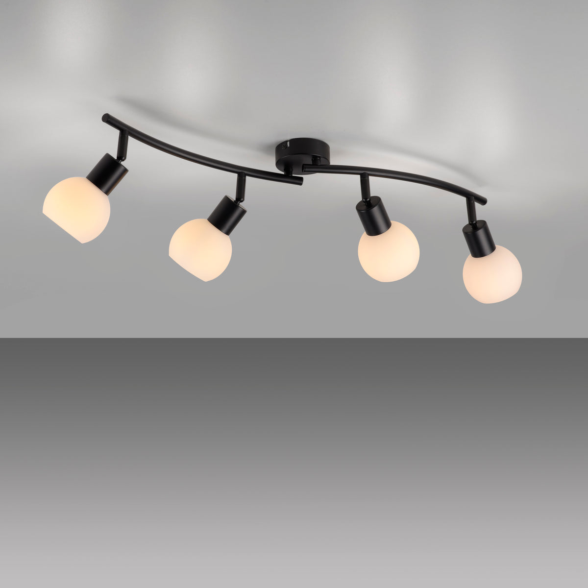Vue de dessous montrant les quatre spots orientables éclairant un plafond gris