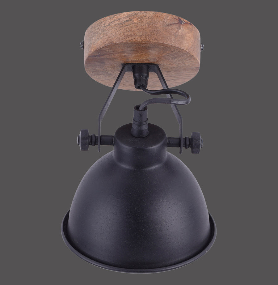Luminaire vu de face sur fond gris, montrant le métal noir et la base en bois.