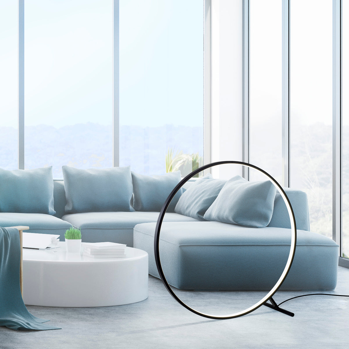 Mise en ambiance dans un salon moderne, grand anneau lumineux près d'un canapé bleu clair.