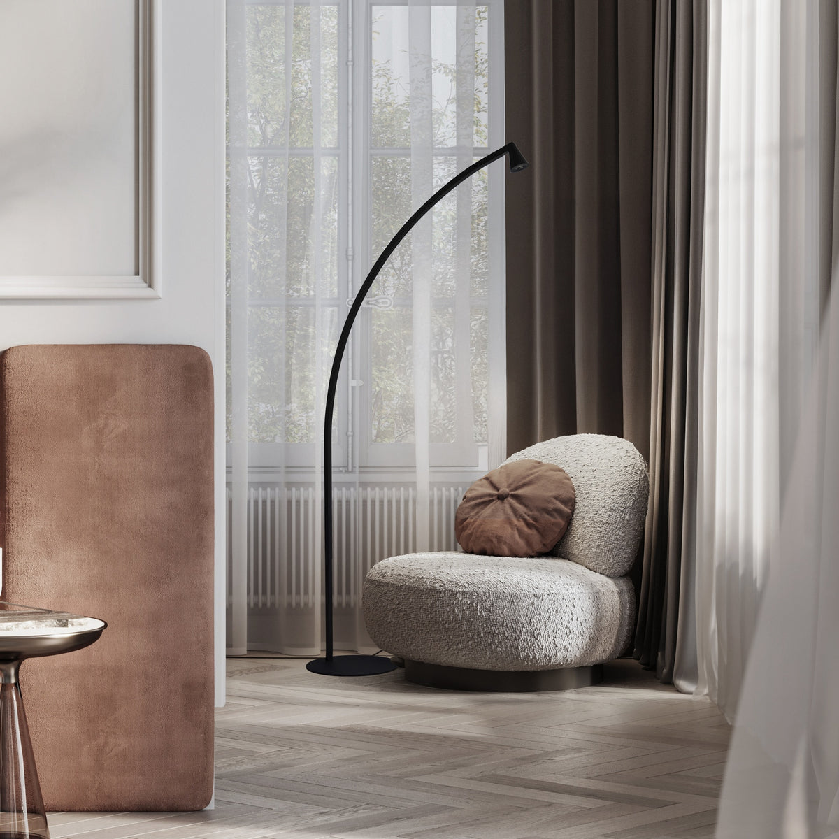 Vue rapprochée du lampadaire courbé noir éclairant un fauteuil devant des rideaux beiges