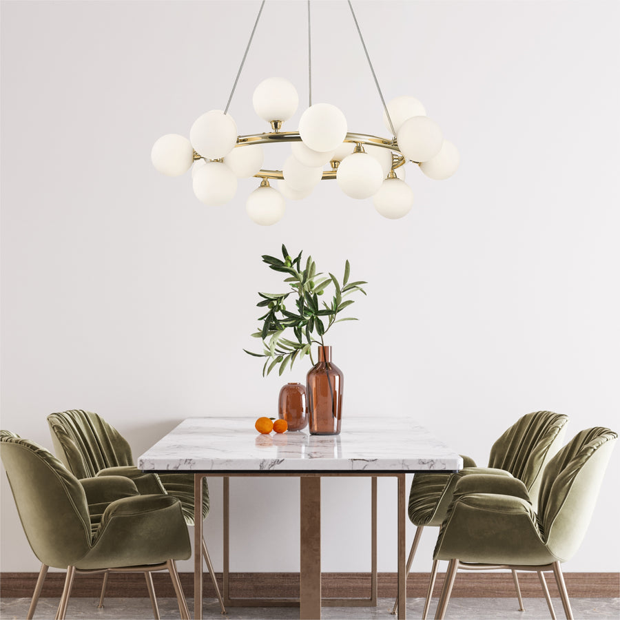 Suspension installée au-dessus d'une table à manger en marbre avec chaises vertes et vase.