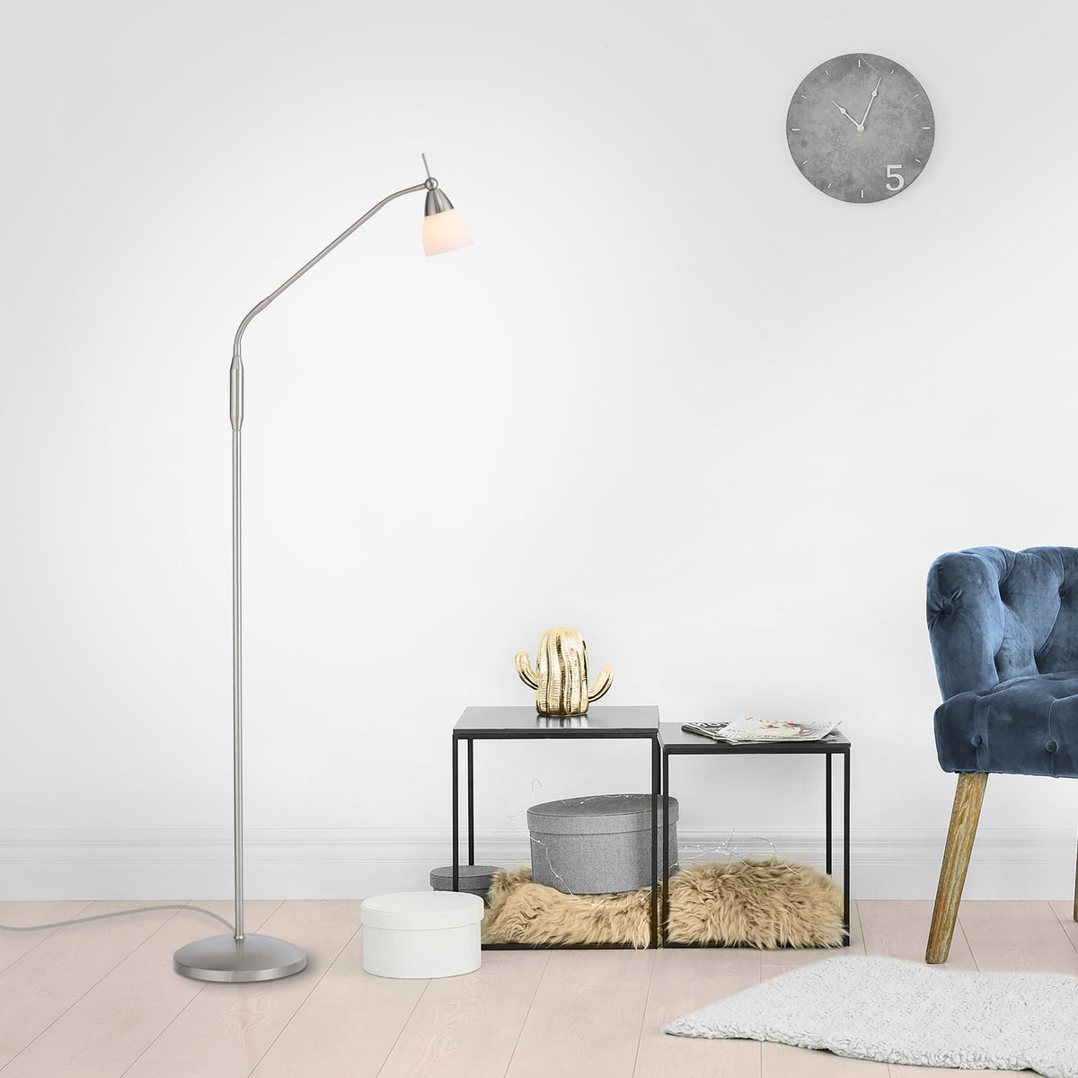 Mise en ambiance dans un salon avec lampadaire allumé près d'une table basse et fauteuil.