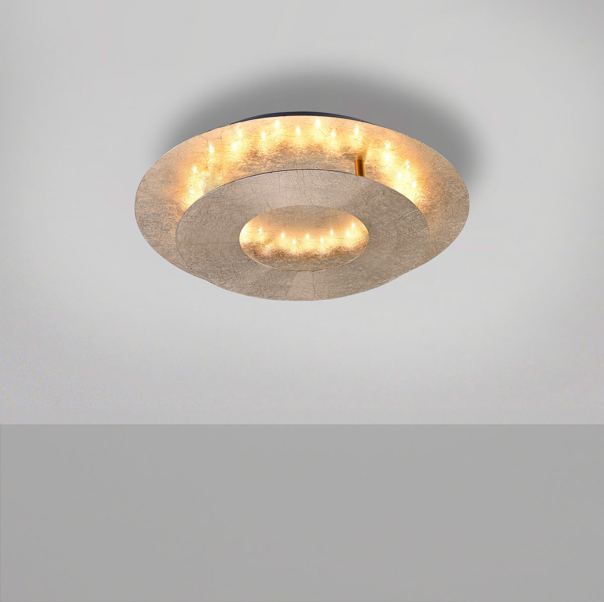 Vue plongeante du plafonnier éclairé, diffusant une lumière chaude et indirecte au plafond.