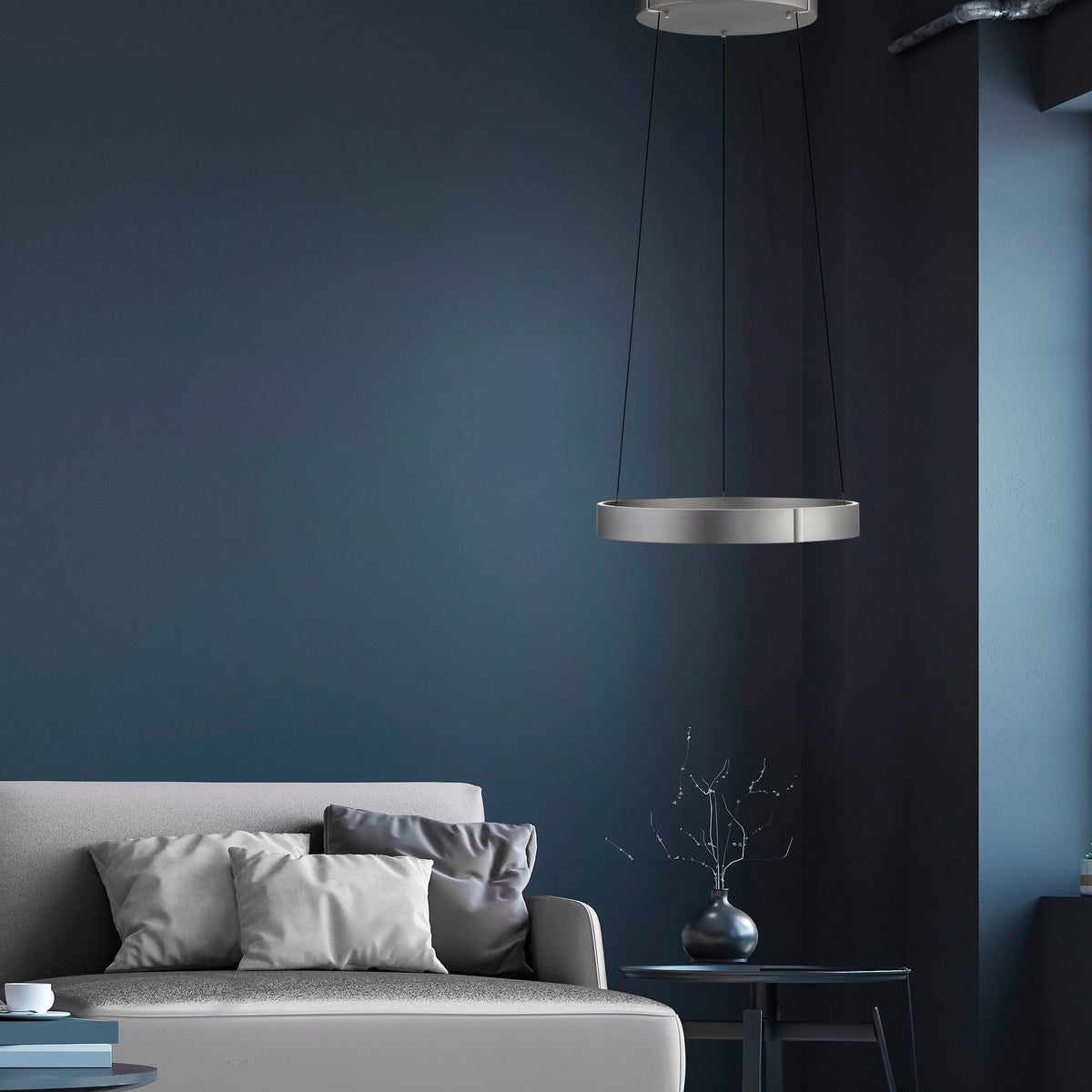 Mise en ambiance salon bleu nuit, canapé gris et suspension allumée