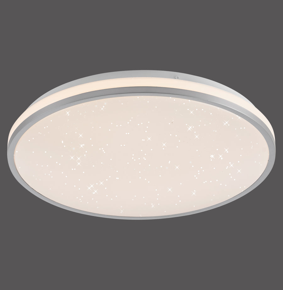 Plafonnier rond argenté allumé, diffuseur blanc avec motif ciel étoilé et liseré gris.