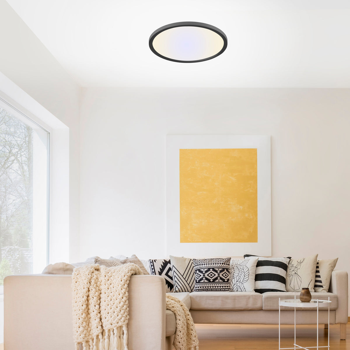 Mise en ambiance du plafonnier allumé au plafond d'un salon au décor clair