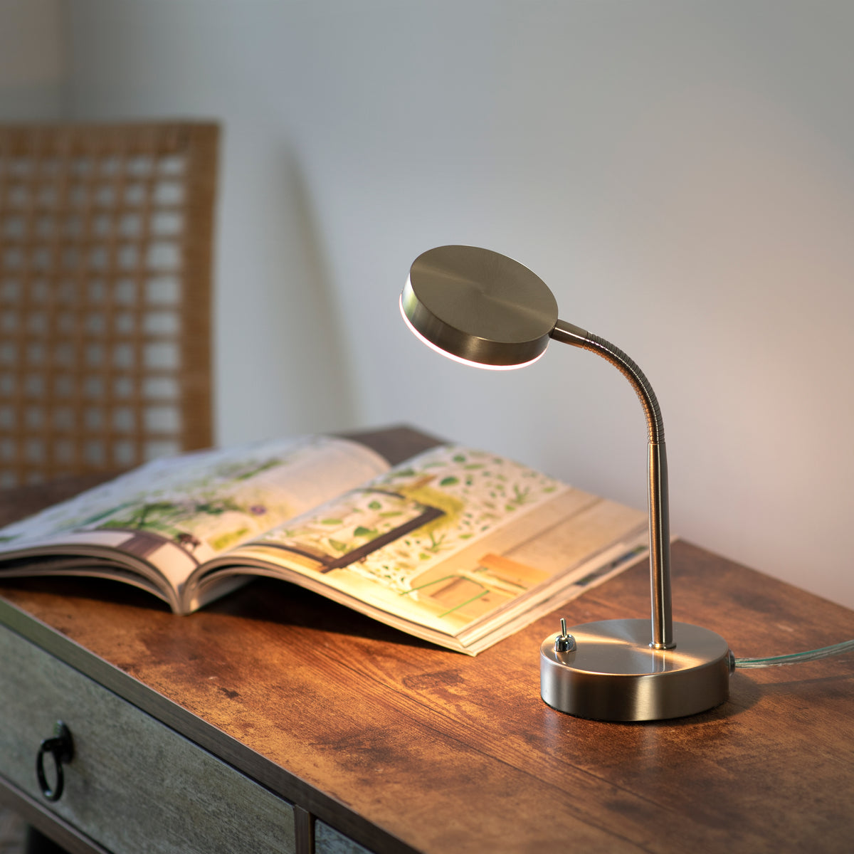 Mise en ambiance sur un bureau en bois avec magazine ouvert