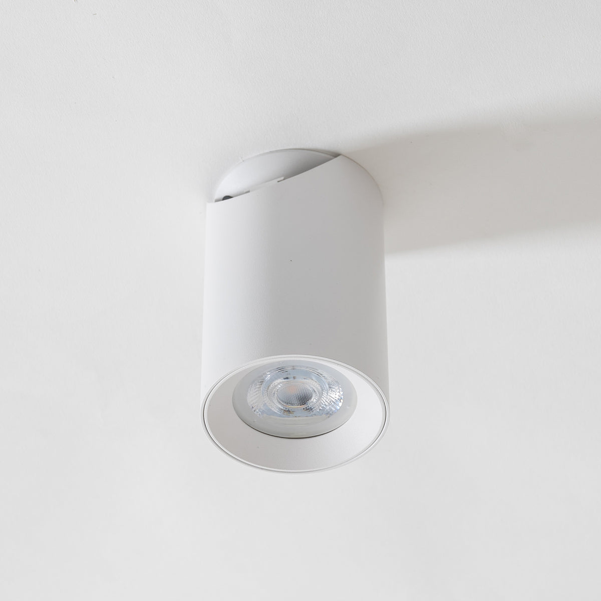 Spot blanc installé au plafond, orienté vers le bas en éclairage direct