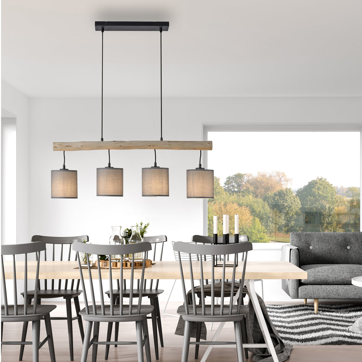 Mise en ambiance au-dessus d'une table à manger en bois, chaises grises et grande baie vitrée.