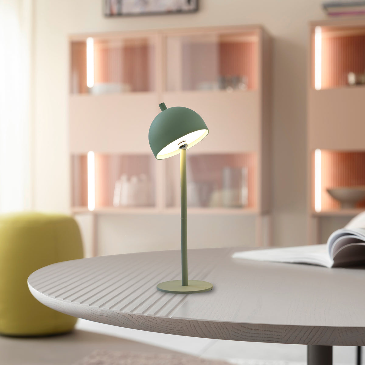 Mise en ambiance : lampe allumée posée sur une table en bois clair