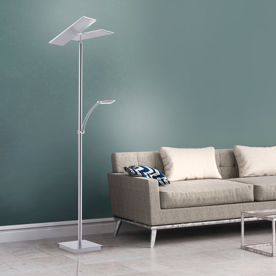 Mise en situation dans un salon, lampadaire allumé près d'un canapé et mur vert.