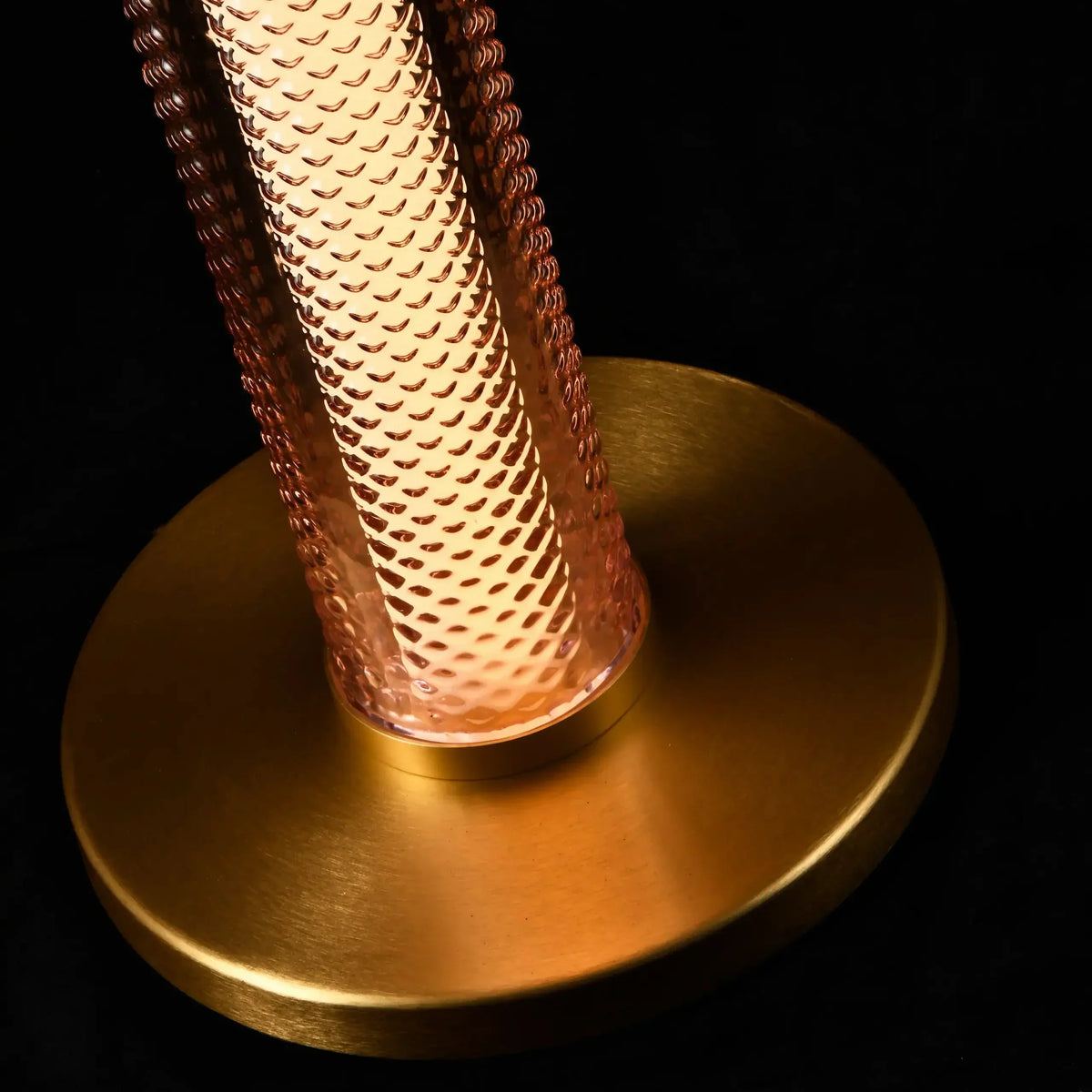 Gros plan de la base dorée ronde et du verre texturé du lampadaire