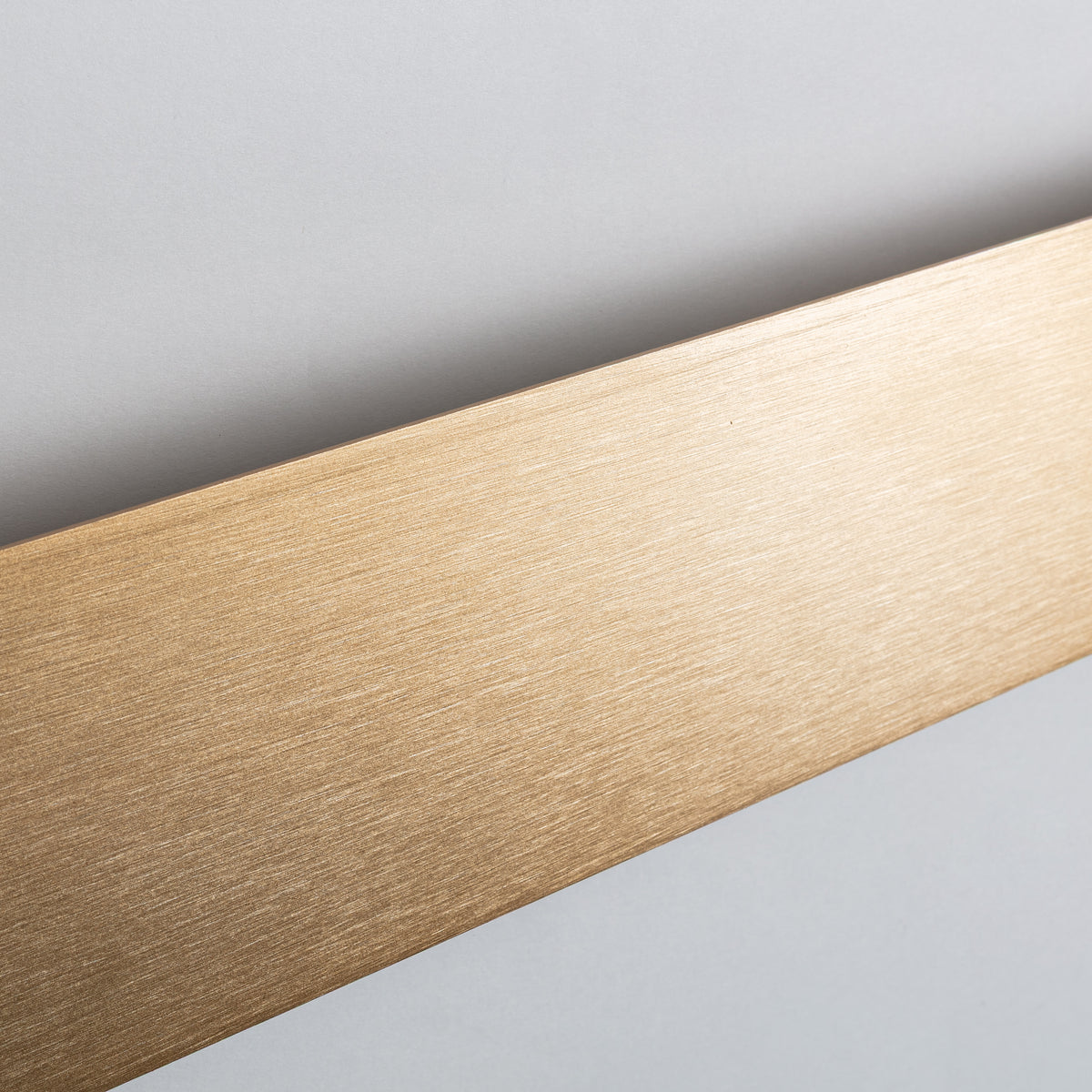 Gros plan de la surface dorée brossée avec reflets et texture fine