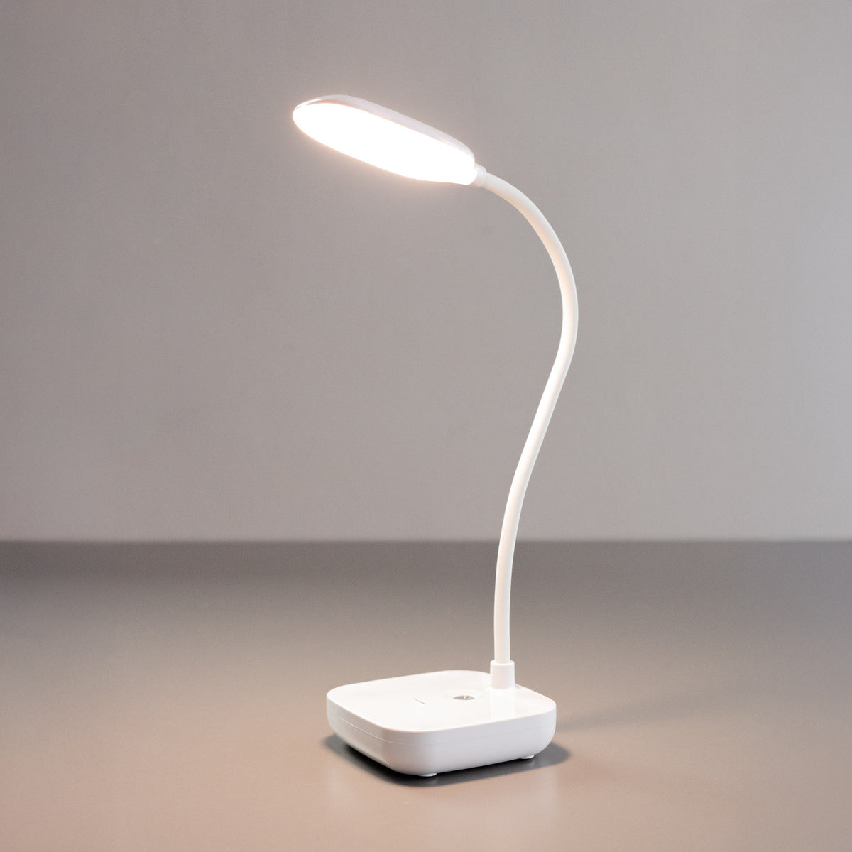 Lampe de bureau allumée, tête ovale diffusant une lumière blanche