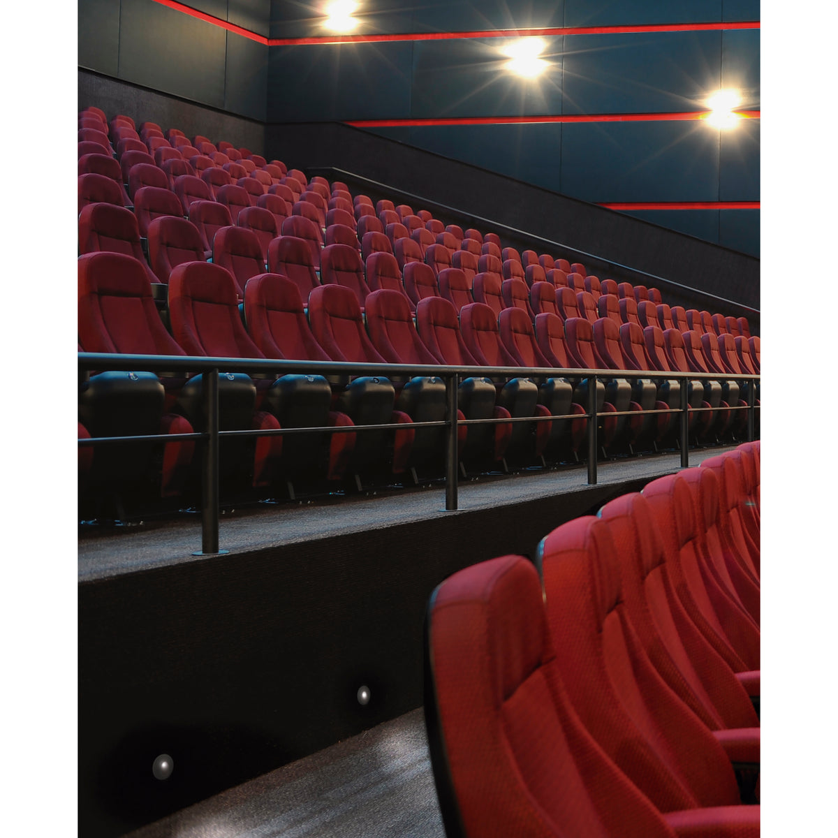 Mise en ambiance dans une salle de cinéma, petits spots encastrés éclairant les marches.