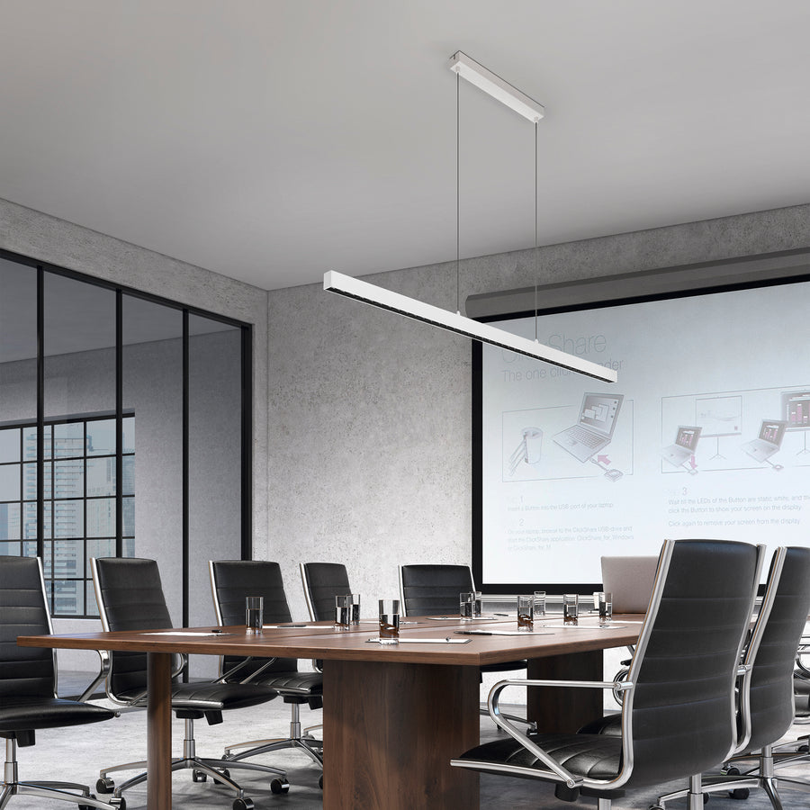 Suspension linéaire blanche allumée au-dessus d'une table de réunion dans un bureau.