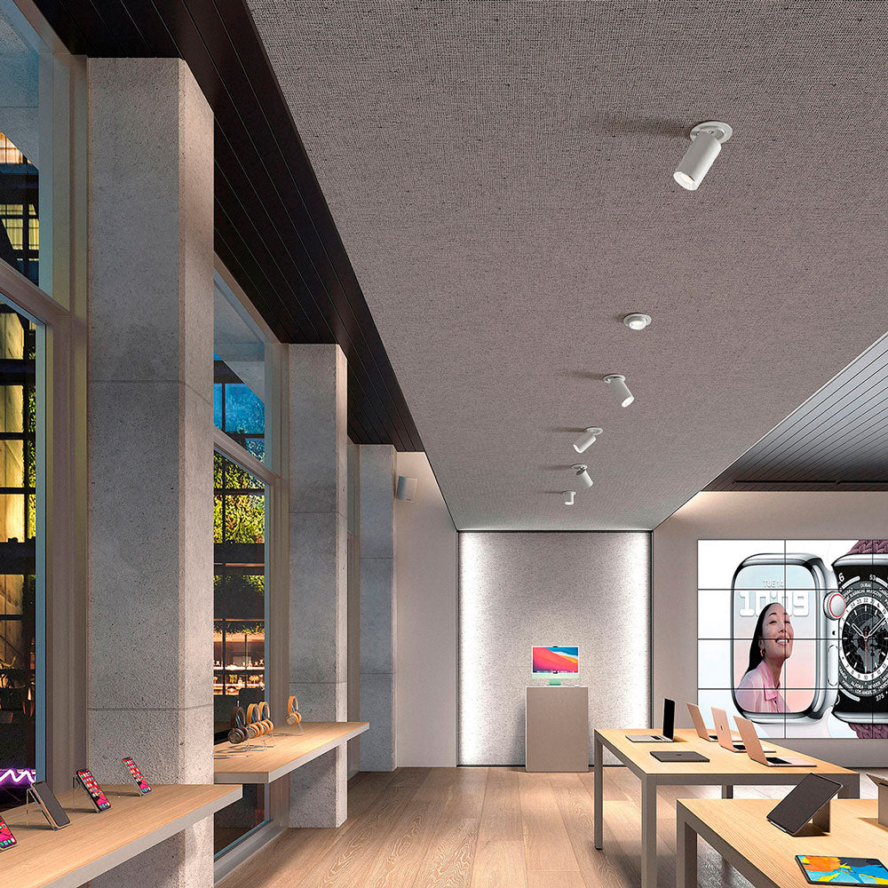 Mise en ambiance dans un magasin, plusieurs spots blancs orientables fixés au plafond texturé.