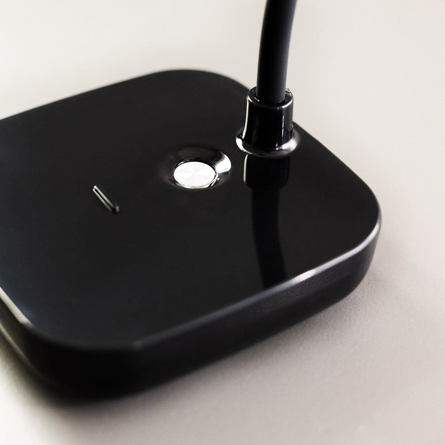 Gros plan sur la base noire brillante avec bouton tactile et fixation du col.