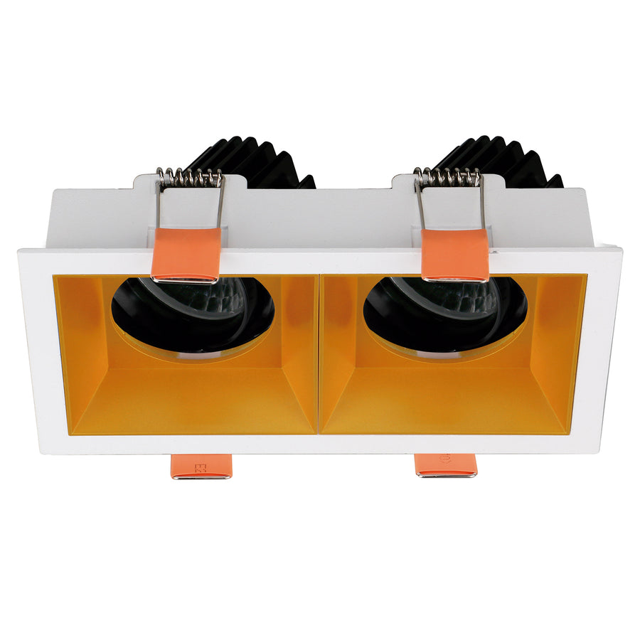 Détail de la finition intérieure dorée du spot double, avec optiques noires et clips orange.