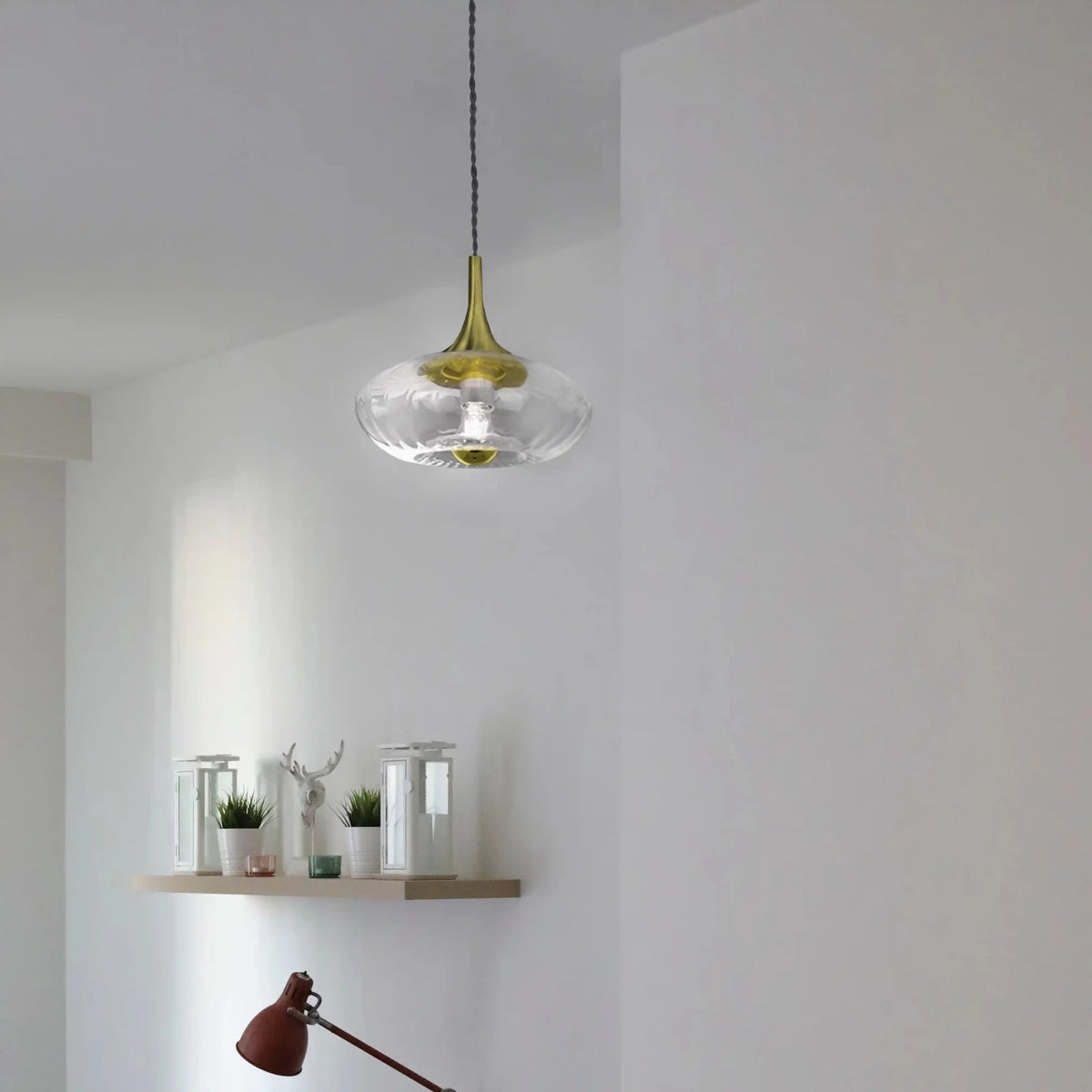 Suspension en verre transparent suspendue dans une pièce blanche au-dessus d'une étagère