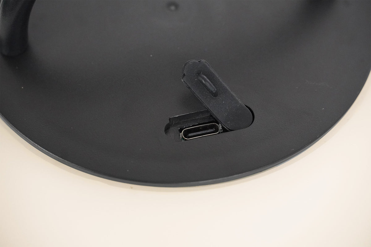 Détail du dessous noir avec trappe souple ouverte sur le port de charge USB-C