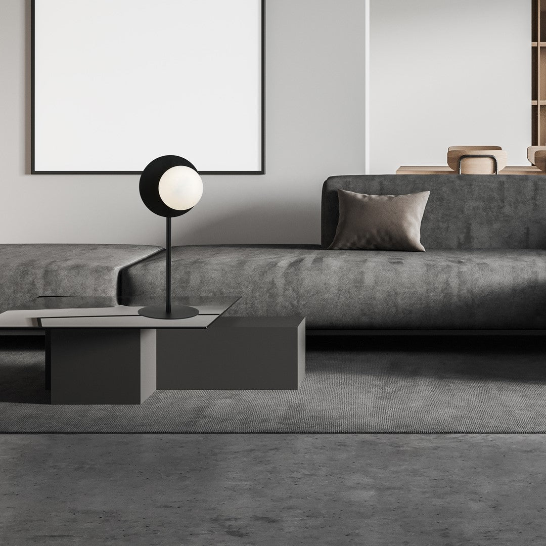 Mise en ambiance dans un salon moderne, lampe posée sur table basse grise.