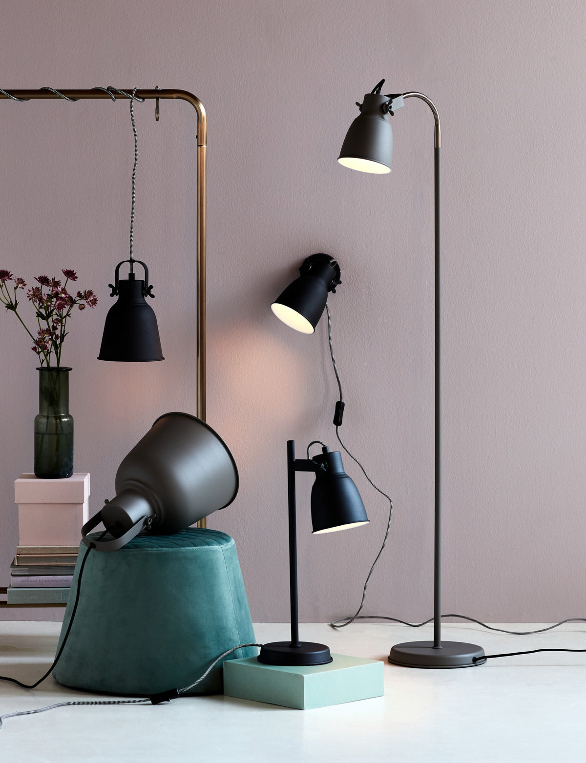 Scène de collection avec suspension, lampe à poser, applique et lampadaire noirs.