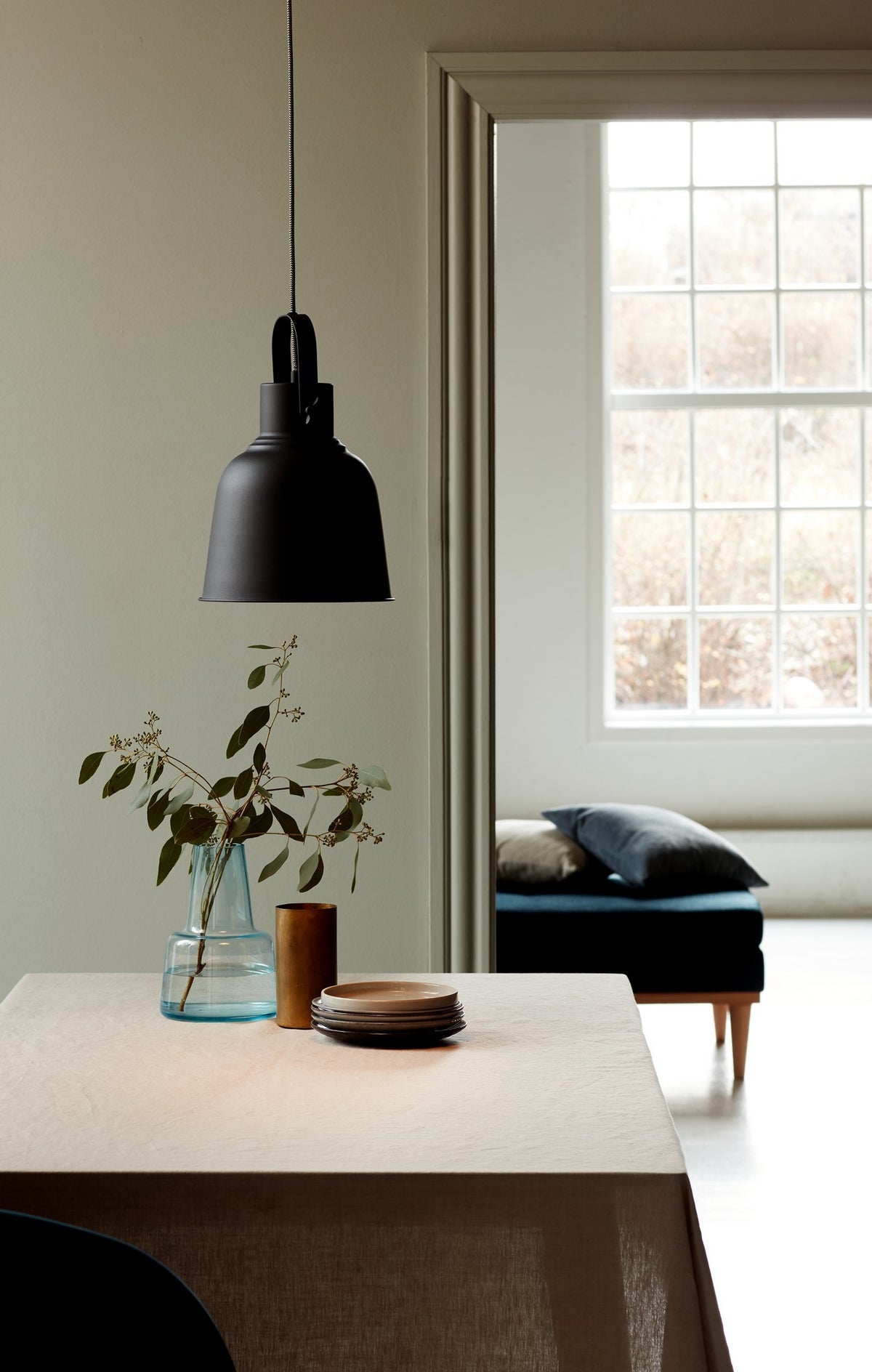 Mise en ambiance au-dessus d'une table dressée avec vase, dans un intérieur clair.