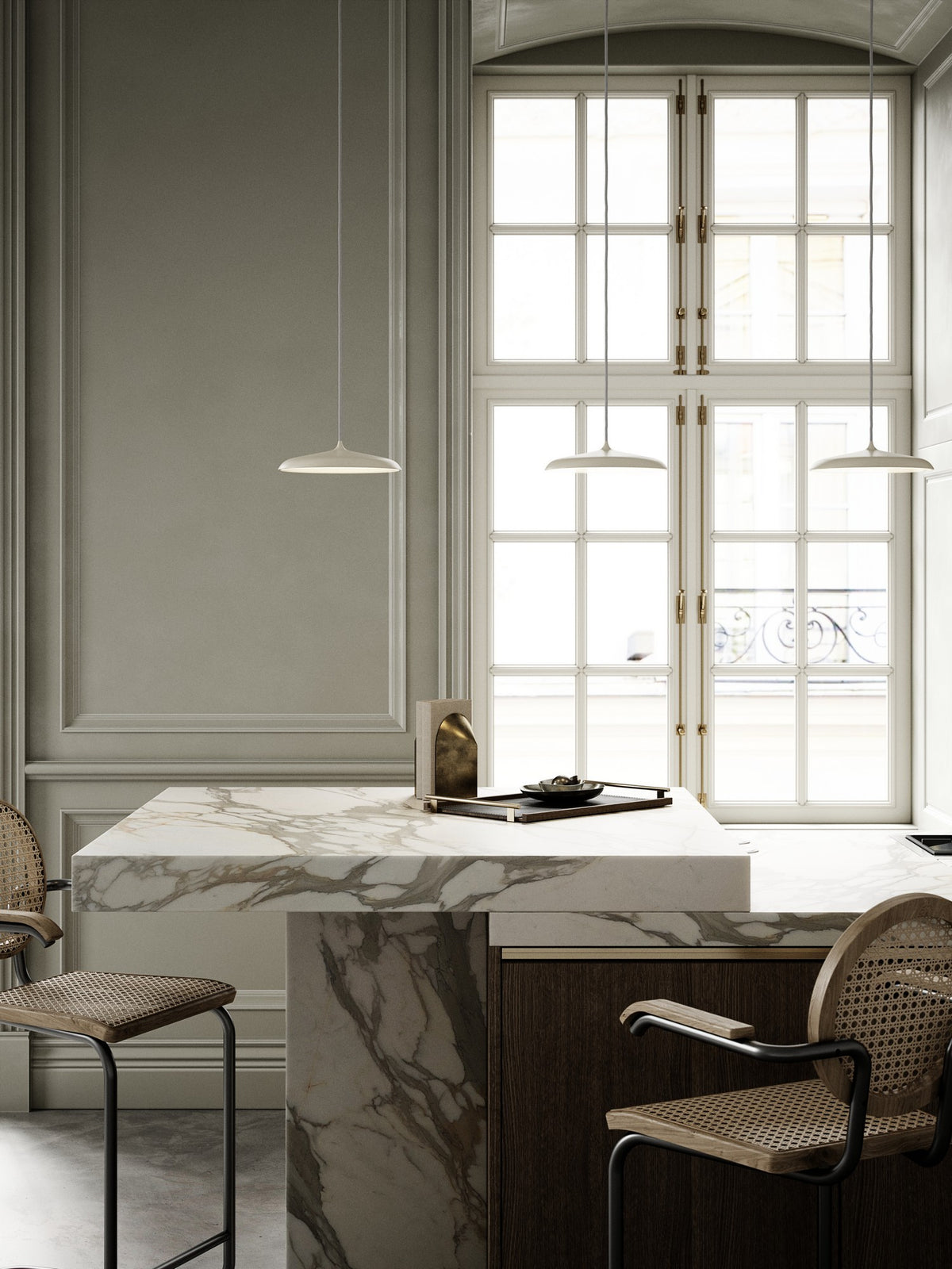 Mise en ambiance dans une cuisine claire avec îlot en marbre et chaises cannées