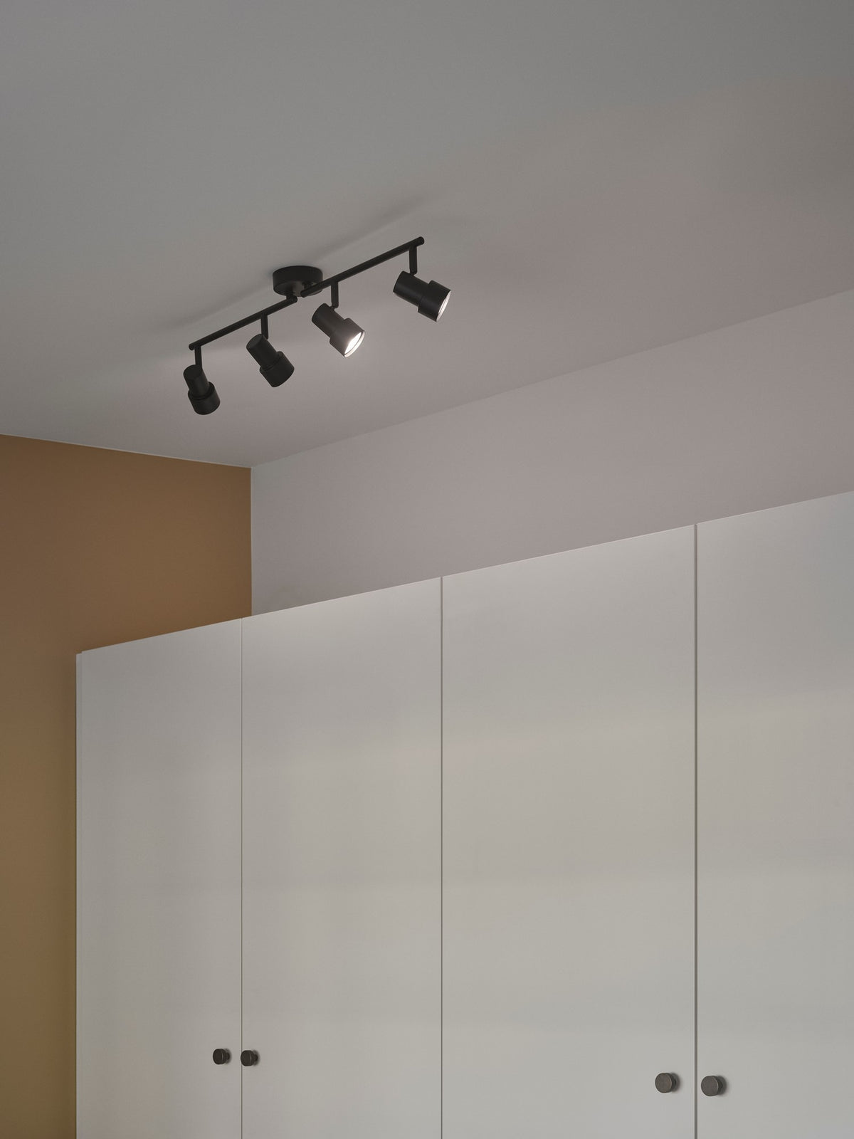 Mise en ambiance du plafonnier fixé au plafond, éclairant une armoire dans une chambre