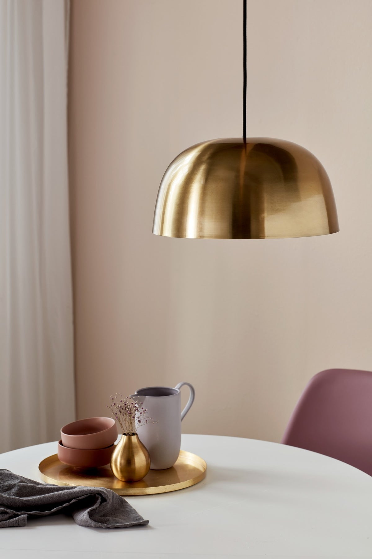 Mise en ambiance au-dessus d'une table ronde avec vaisselle et linge gris