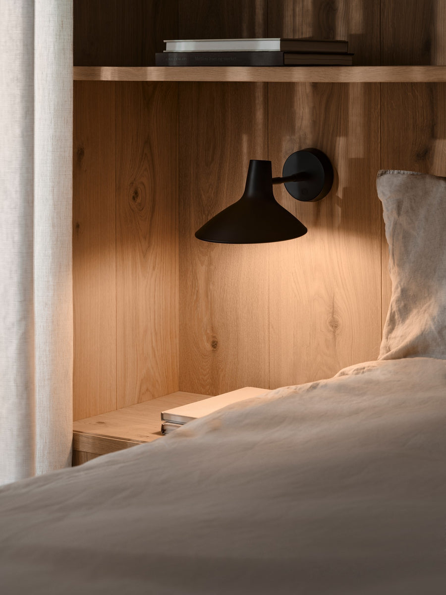 Mise en ambiance chambre avec applique fixée sur tête de lit en bois