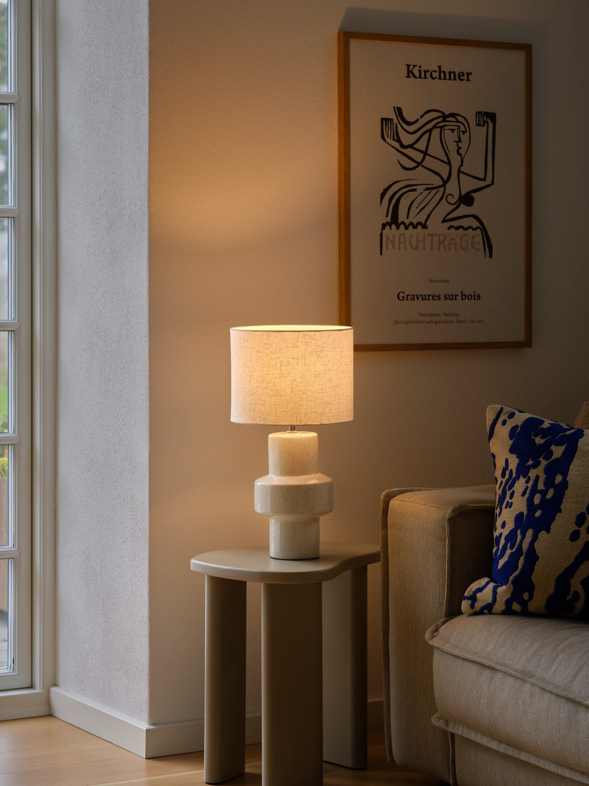 Mise en ambiance sur une table d'appoint, près d'un fauteuil et d'une affiche