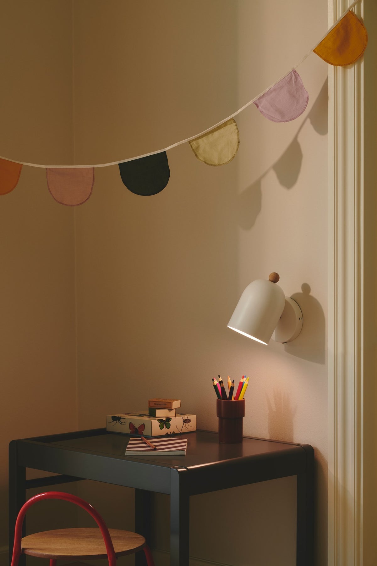 Mise en ambiance chambre d'enfant, bureau éclairé sous guirlande colorée
