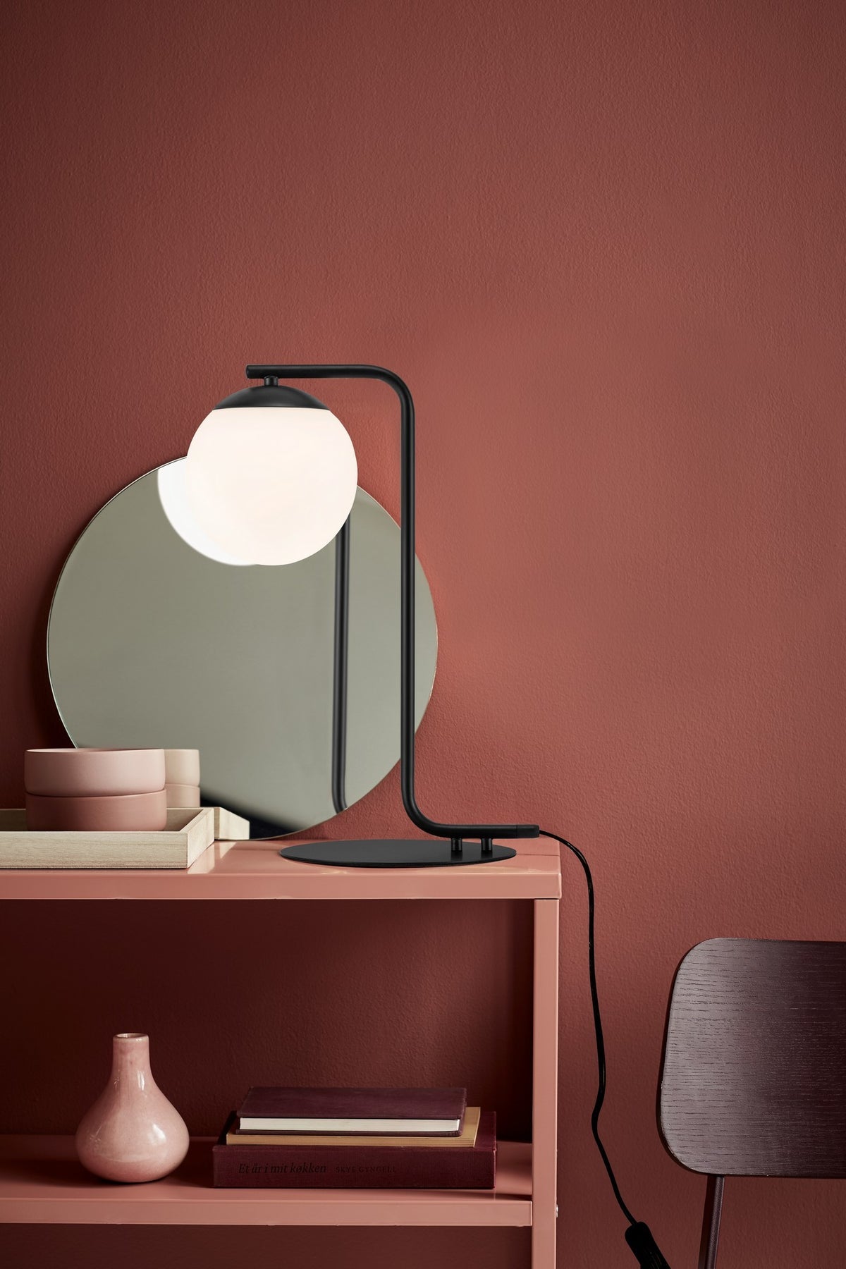 Mise en ambiance de la lampe noire sur console, intérieur rouge brique