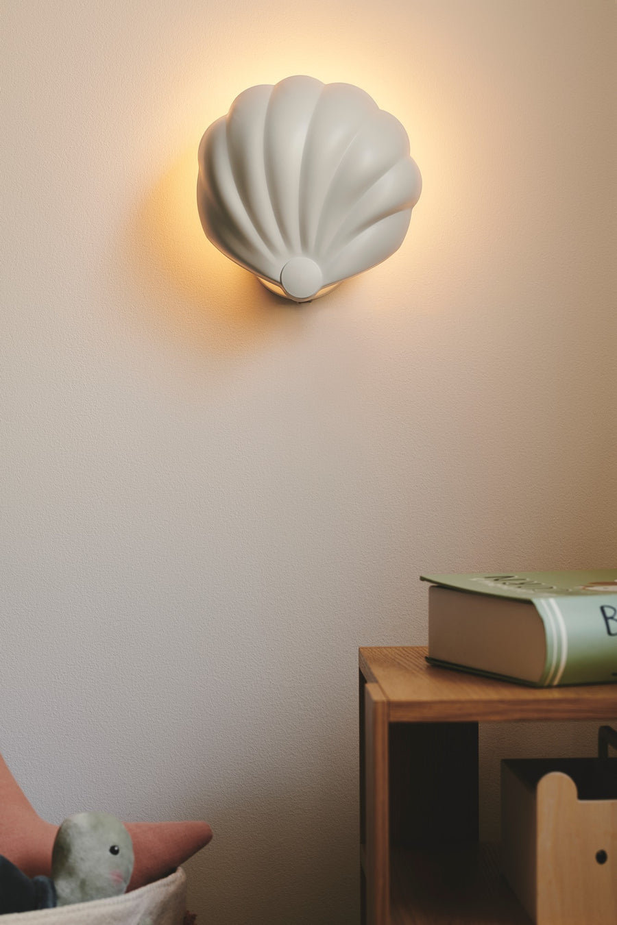 Gros plan du luminaire mural allumé diffusant une lumière dorée sur le mur