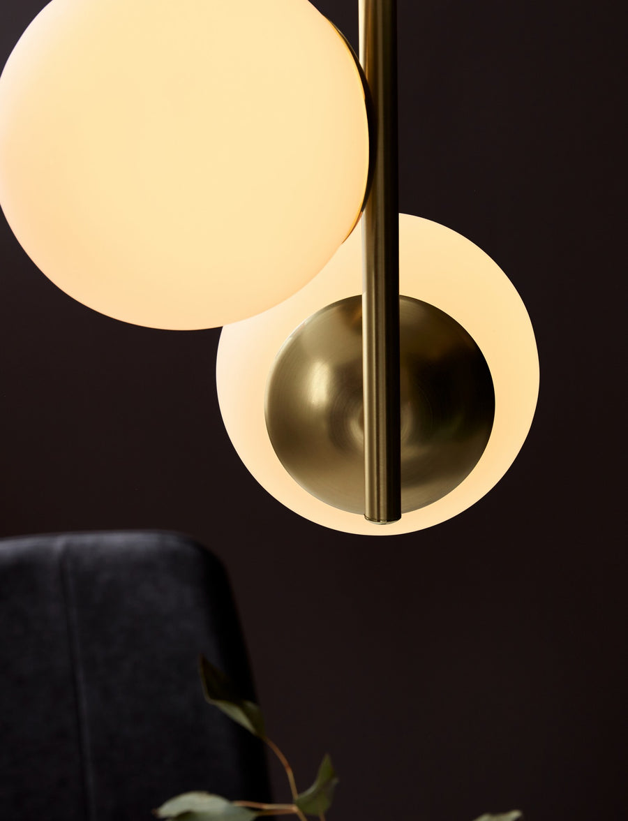 Très gros plan sur la finition laiton et un globe en verre éclairé, arrière-plan sombre.