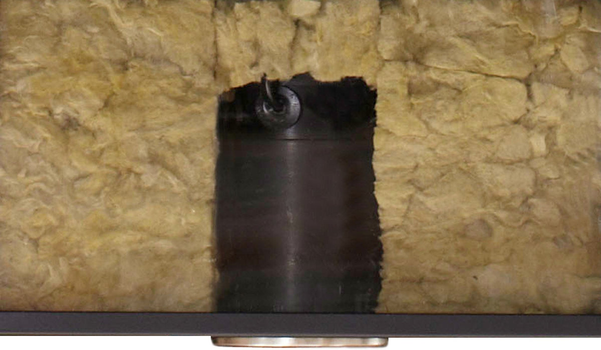 Photographie du boîtier encastré dans la laine de verre sous le plafond, montrant la pose