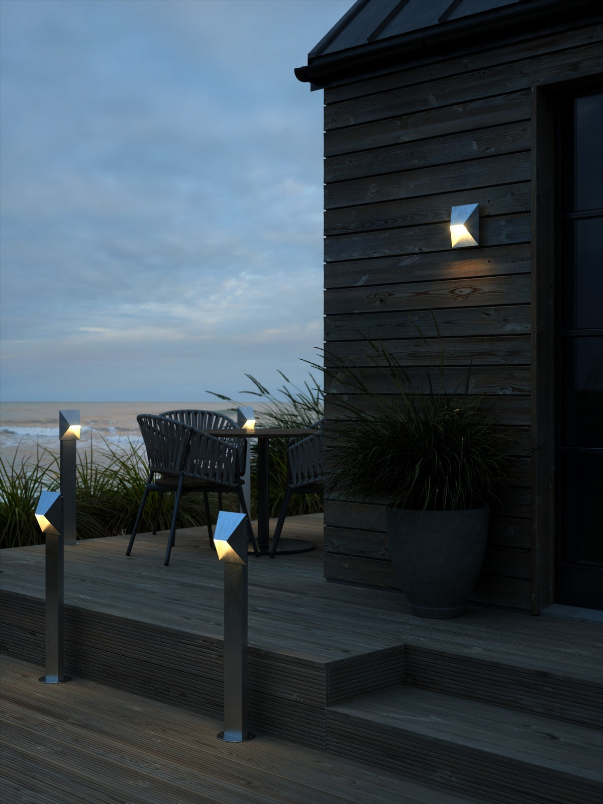 Mise en ambiance nocturne sur une terrasse en bois avec plusieurs bornes allumées